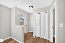 Entryway featuring wood-finish flooring, light gray wall paint, and white trim - 