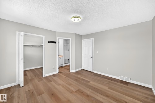 Spacious room with wood-finish flooring, light gray walls, and white trim - 203 84 Street Sw, Edmonton, AB - Indoor Photo Showing Other Room