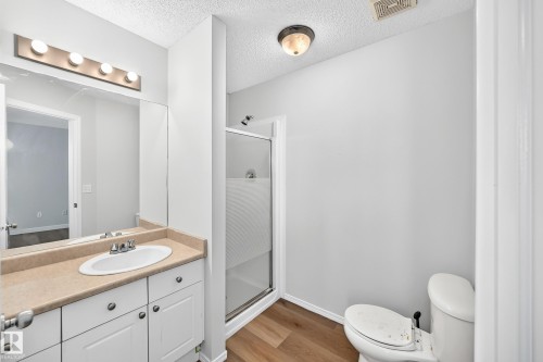 Bathroom featuring a vanity with a light-toned countertop, white cabinetry, and an oval undermount sink - 203 84 Street Sw, Edmonton, AB - Indoor Photo Showing Bathroom