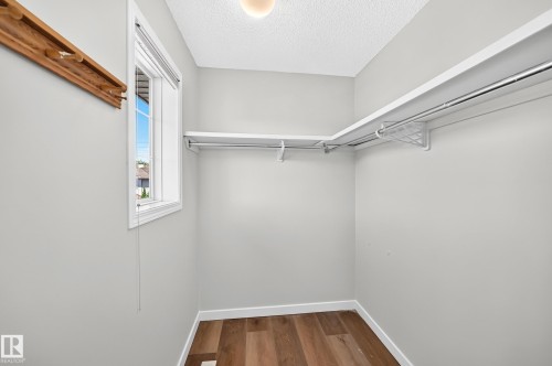 Walk-in closet with wood-finish flooring, light gray wall paint, and white trim - 203 84 Street Sw, Edmonton, AB - Indoor With Storage