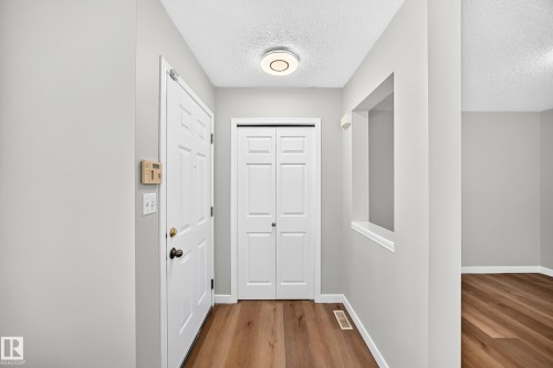 Entryway featuring wood-finish flooring, white paneled doors, and a built-in architectural pass-through - 203 84 Street Sw, Edmonton, AB - Indoor Photo Showing Other Room