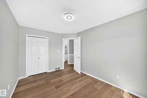 Light gray painted walls with wood-finish flooring - 203 84 Street Sw, Edmonton, AB - Indoor Photo Showing Other Room