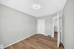 Room featuring wood-finish flooring, light gray walls, white baseboards, and a ceiling-mounted light fixture - 