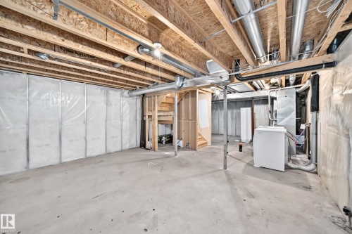 Unfinished basement with exposed ceiling joists, concrete flooring, and insulated perimeter walls - 203 84 Street Sw, Edmonton, AB - Indoor Photo Showing Basement