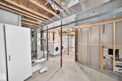 Unfinished basement space featuring exposed wood joists, ductwork, and framing for future customization - 
