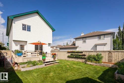 Spacious backyard featuring a manicured lawn, multi-level wood deck, and perimeter wood fencing - 203 84 Street Sw, Edmonton, AB - Outdoor With Deck Patio Veranda