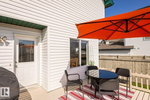 Exterior deck with light-colored flooring, white siding, and a white door with window blinds - 203 84 Street Sw, Edmonton, AB - Outdoor With Deck Patio Veranda With Exterior