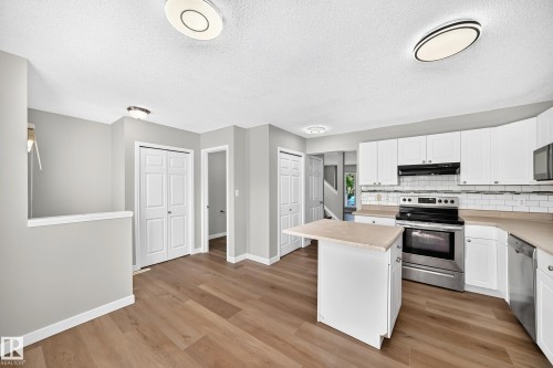 Kitchen featuring white cabinetry, light countertops, subway tile backsplash, and stainless steel appliances - 203 84 Street Sw, Edmonton, AB - Indoor Photo Showing Kitchen