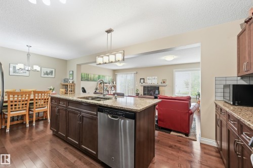 Kitchen island with granite countertop, stainless steel dishwasher, and undermount sink - 1111 176 Street Sw, Edmonton, AB 