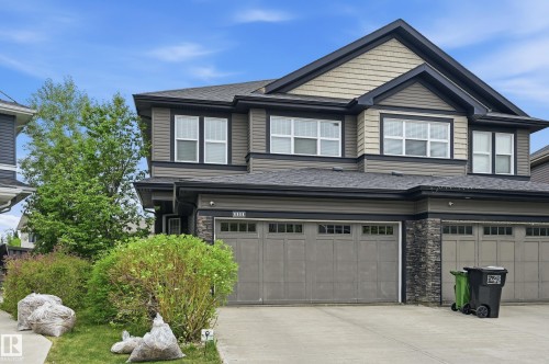Modern two-story exterior with horizontal siding, stone facade accents, and an attached two-car garage - 1111 176 Street Sw, Edmonton, AB 
