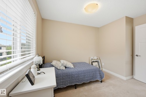 Soft neutral wall paint, textured ceiling, flush mount ceiling light, white window blinds, and light tone carpet flooring - 1111 176 Street Sw, Edmonton, AB 