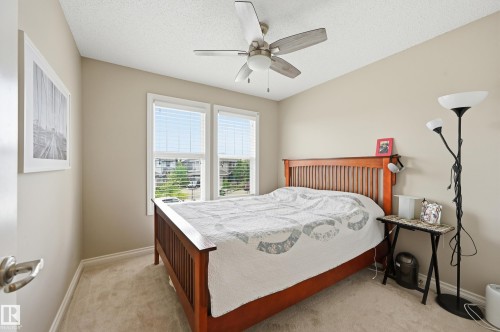 Soft neutral wall color, two large windows with blinds, ceiling fan, and carpeted flooring - 1111 176 Street Sw, Edmonton, AB 