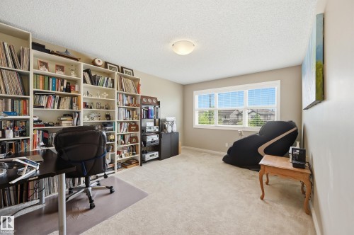 Expansive room with built-in shelving, a large window, and wall-to-wall carpeting - 1111 176 Street Sw, Edmonton, AB 