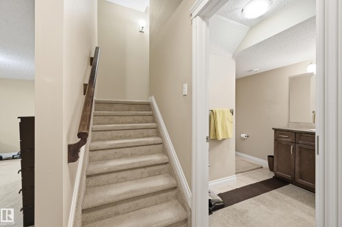 Carpeted staircase with a wood handrail - 1111 176 Street Sw, Edmonton, AB 