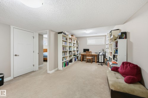 Carpeted room featuring multiple built-in shelving units and a window with blinds - 1111 176 Street Sw, Edmonton, AB 