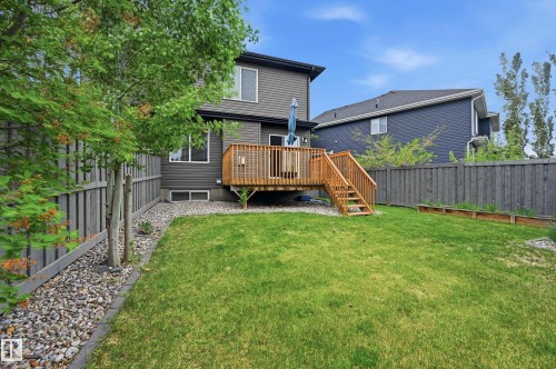 Spacious backyard featuring a wood deck with stairs, a manicured lawn, and perimeter fencing - 1111 176 Street Sw, Edmonton, AB 