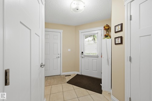 Tiled flooring entry with a white paneled door and overhead light fixture - 1111 176 Street Sw, Edmonton, AB 