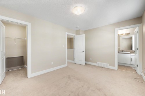 Carpeted room with neutral wall tones and a ceiling-mounted light fixture - 2125 24 Street Nw, Edmonton, AB 