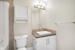 Bathroom featuring a vanity with a rectangular vessel sink, white cabinet storage, wall-mounted medicine cabinet, and a full-width mirror - 