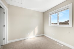 Neutral wall color with plush carpeting, featuring a window with white trim and a white paneled door - 
