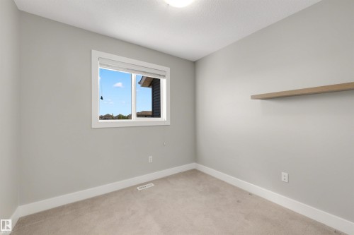 Neutral wall paint, carpet flooring, window with white trim, recessed lighting, and a built-in floating shelf - 2125 24 Street Nw, Edmonton, AB 