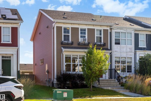 Two-story residential structure with a brown and red siding facade, multiple windows, and a front entrance with steps - 2125 24 Street Nw, Edmonton, AB 