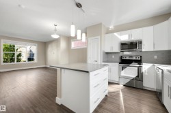 Modern kitchen with white cabinetry and stainless steel appliances - 