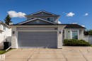 Two-story exterior with light gray siding, white brick accents, an attached garage, and a bay window - 89 Ozerna Road Nw, Edmonton, AB 