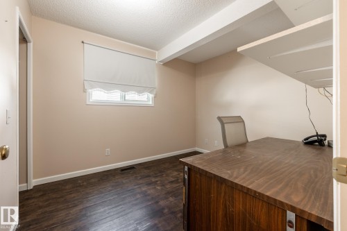 Wood-finish flooring throughout, featuring a single window with a white blind, and a neutral wall color - 89 Ozerna Road Nw, Edmonton, AB 