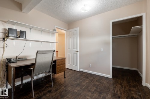 Wood-finish flooring, overhead lighting, interior door, and closet with built-in shelving - 89 Ozerna Road Nw, Edmonton, AB 