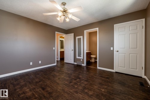 Wood-finish flooring, ceiling fan with integrated lighting, paneled interior doors, and a neutral wall color - 89 Ozerna Road Nw, Edmonton, AB 