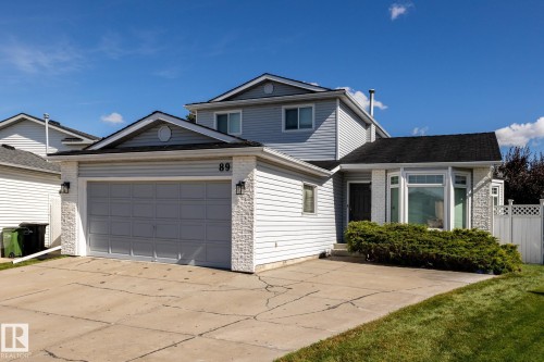 Two-story residence featuring light gray siding, white stone veneer accents, and a dark shingle roof - 89 Ozerna Road Nw, Edmonton, AB 
