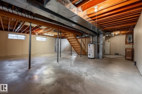 Unfinished basement featuring exposed wood joists, concrete flooring, and utility windows - 89 Ozerna Road Nw, Edmonton, AB 
