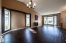 Spacious room with dark wood-finish flooring, vaulted ceiling, and a prominent bay window - 89 Ozerna Road Nw, Edmonton, AB 