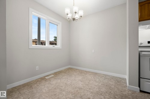 Neutral wall color, tiled flooring, white-framed window, and a ceiling-mounted light fixture - 3173 139 Avenue Nw, Edmonton, AB 
