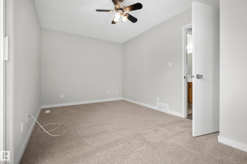 Neutral wall finishes, carpeted flooring, and a ceiling-mounted fan with integrated lighting - 3173 139 Avenue Nw, Edmonton, AB 