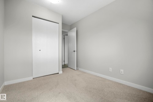 Light grey wall paint, bi-fold closet doors, cream carpet flooring, and white trim - 3173 139 Avenue Nw, Edmonton, AB 