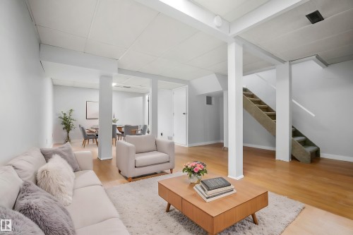 Expansive open-concept space featuring light wood-finish flooring, white walls, and a carpeted staircase - 3173 139 Avenue Nw, Edmonton, AB 