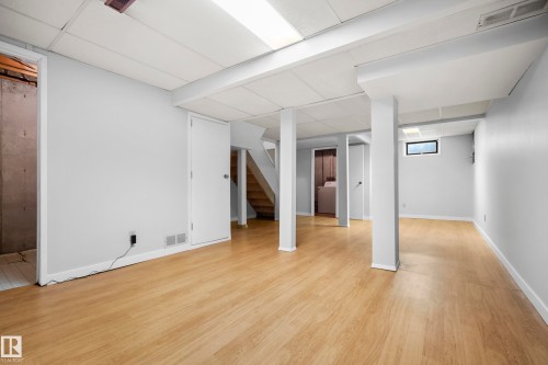 Finished lower level with light wood-finish flooring, recessed lighting, and white trim - 3173 139 Avenue Nw, Edmonton, AB 