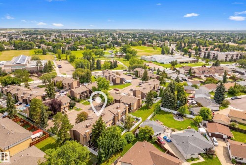 Aerial perspective of a neighborhood featuring multiple residential structures, green spaces, and paved areas - 3173 139 Avenue Nw, Edmonton, AB 