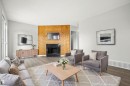Wood-paneled fireplace surround, black firebox, light wood-finish flooring, and light gray wall paint - 3173 139 Avenue Nw, Edmonton, AB 