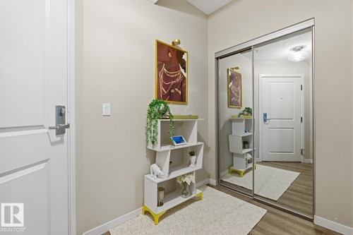 Mirrored sliding closet doors with neutral wall paint and wood-finish flooring - #155 1818 Rutherford Rd Sw, Edmonton, AB 