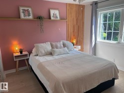Bedroom featuring a light wood-finish flooring, a grid-paned window, and a wood slat accent wall - 