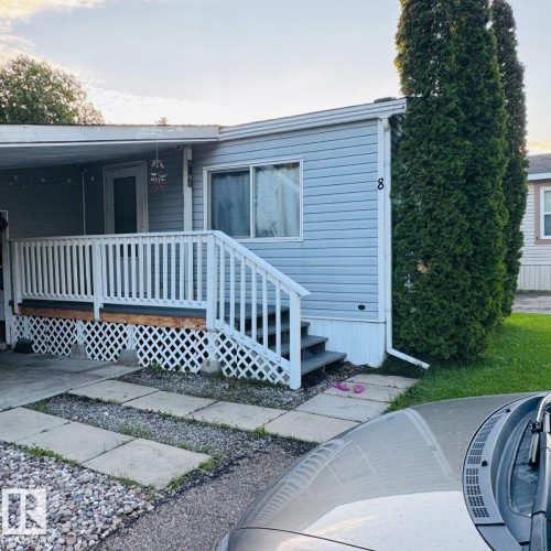 Light blue siding exterior featuring white trim and a covered front porch with white railing - 8 The Parkway Northwest, Edmonton, AB - Outdoor With Deck Patio Veranda