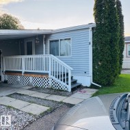 Light blue siding exterior featuring white trim and a covered front porch with white railing - 