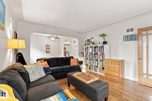 Hardwood flooring, arched doorway, recessed window, built-in shelving, and a wood-panel interior door - 10943 72 Avenue Nw, Edmonton, AB 