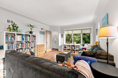 Hardwood-finish flooring, built-in shelving, bay window, and a glass-paneled door - 10943 72 Avenue Nw, Edmonton, AB 