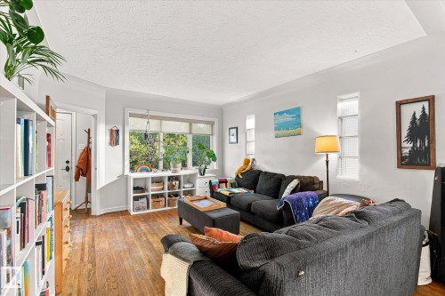Hardwood-finish flooring, built-in shelving, large picture window, and white interior paint - 10943 72 Avenue Nw, Edmonton, AB 