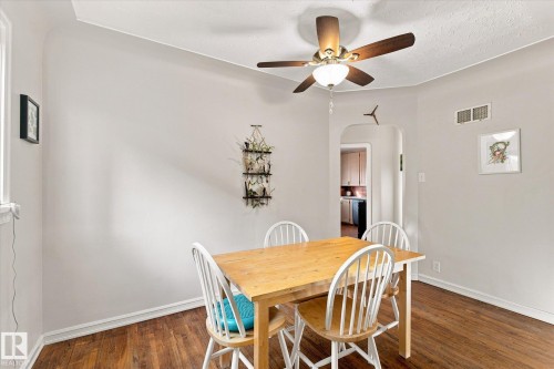 Hardwood-finish flooring, ceiling fan with integrated lighting, arched doorway, and window for natural light - 10943 72 Avenue Nw, Edmonton, AB 