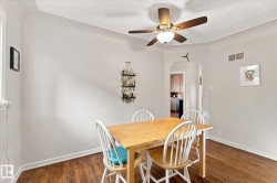 Hardwood-finish flooring, ceiling fan with integrated lighting, arched doorway, and window for natural light - 
